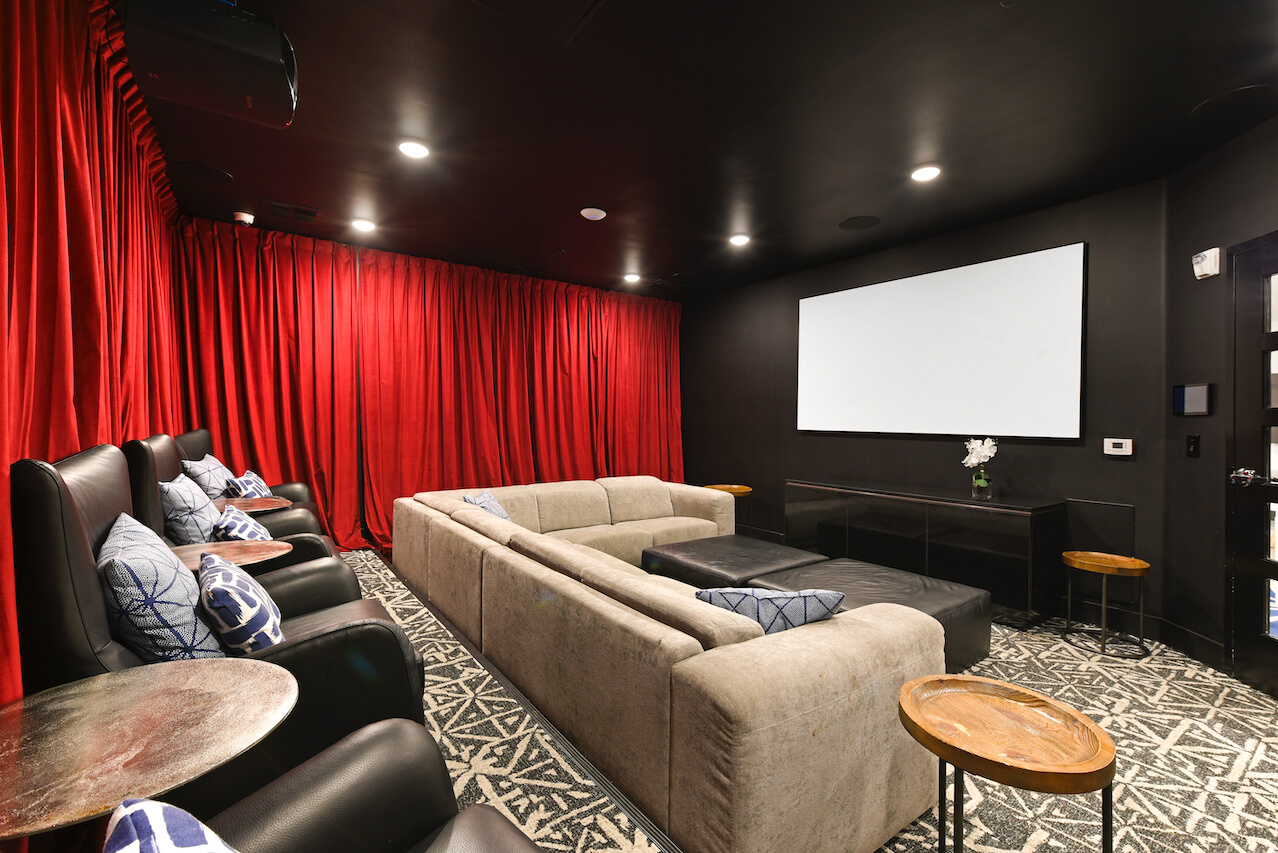 Cozy home theater with red curtains sectional sofa and screens