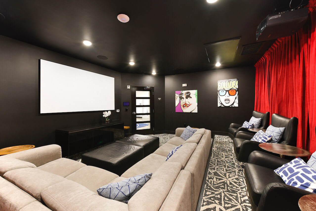 Home theater with a large screen seating and colorful artwork