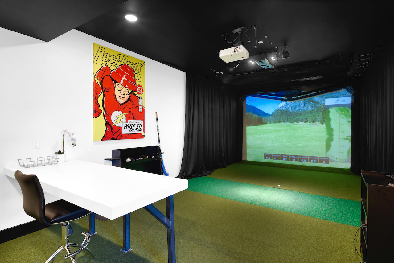 Indoor golf simulator with projection screen and modern decor