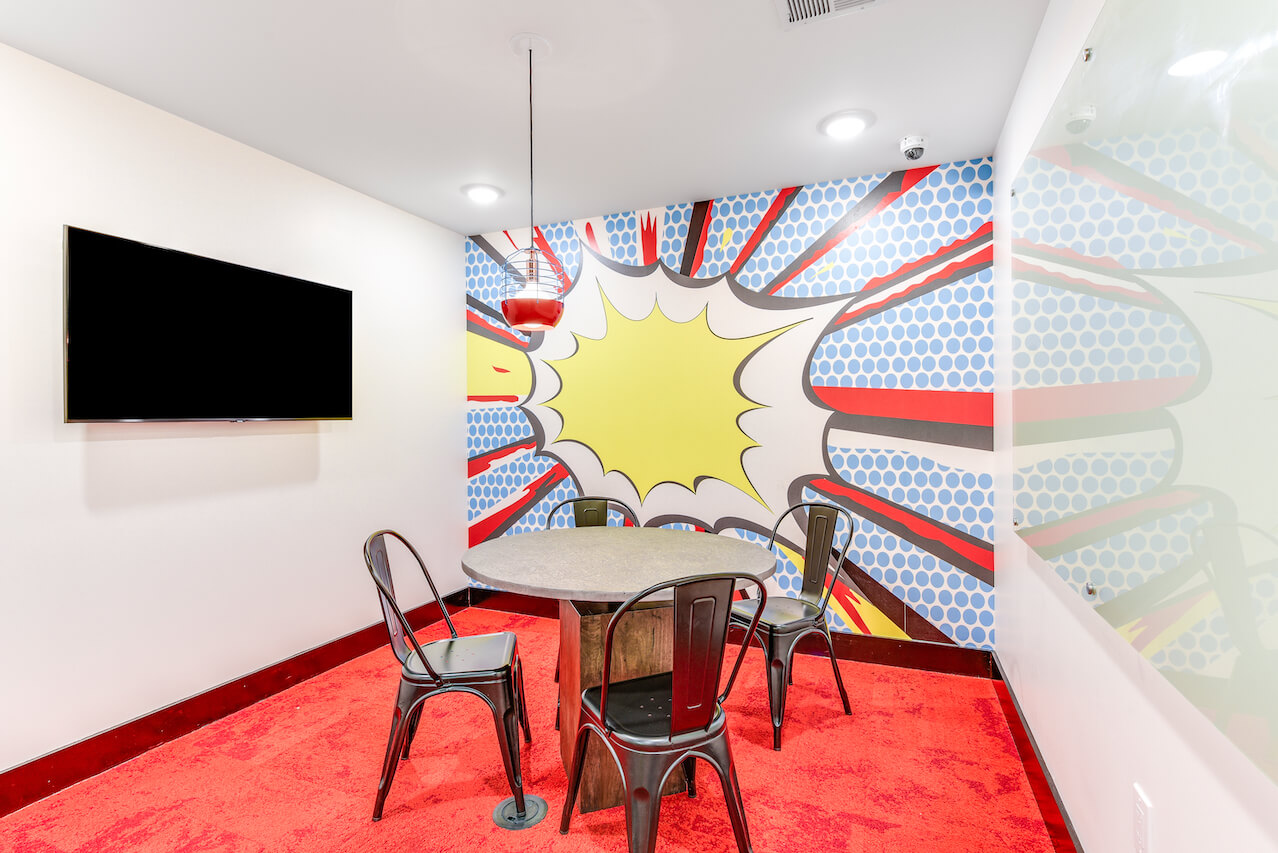 Meeting room with a circular table and colorful comic style wall art