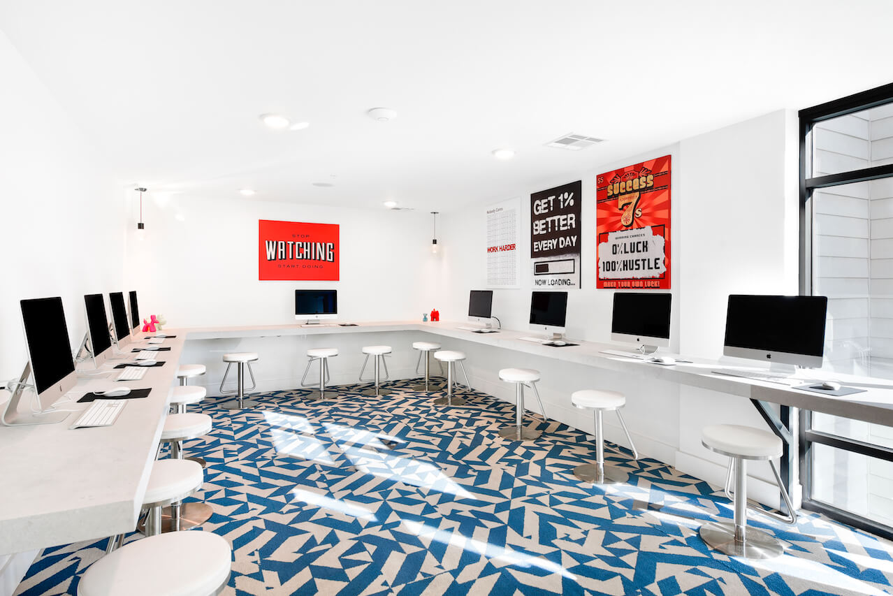 Modern computer lab with iMacs white stools and motivational posters