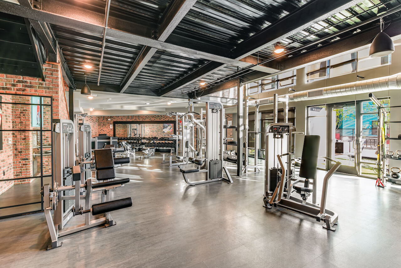 Modern fitness center with workout equipment and natural lighting