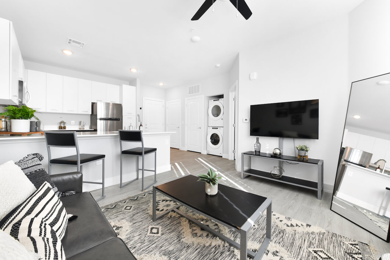 Modern living room with sleek furniture and kitchen access