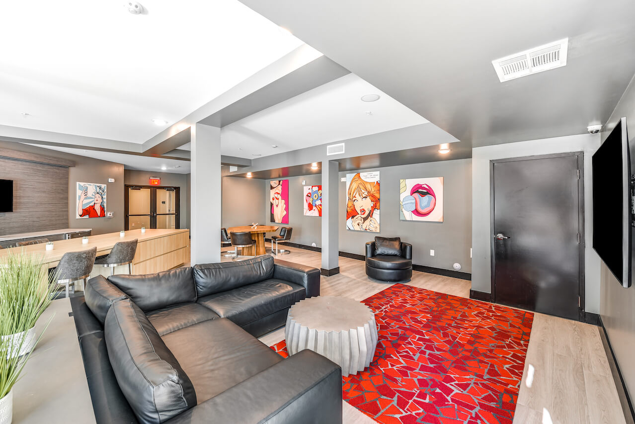 Modern lounge area with black sofas artwork and dining table