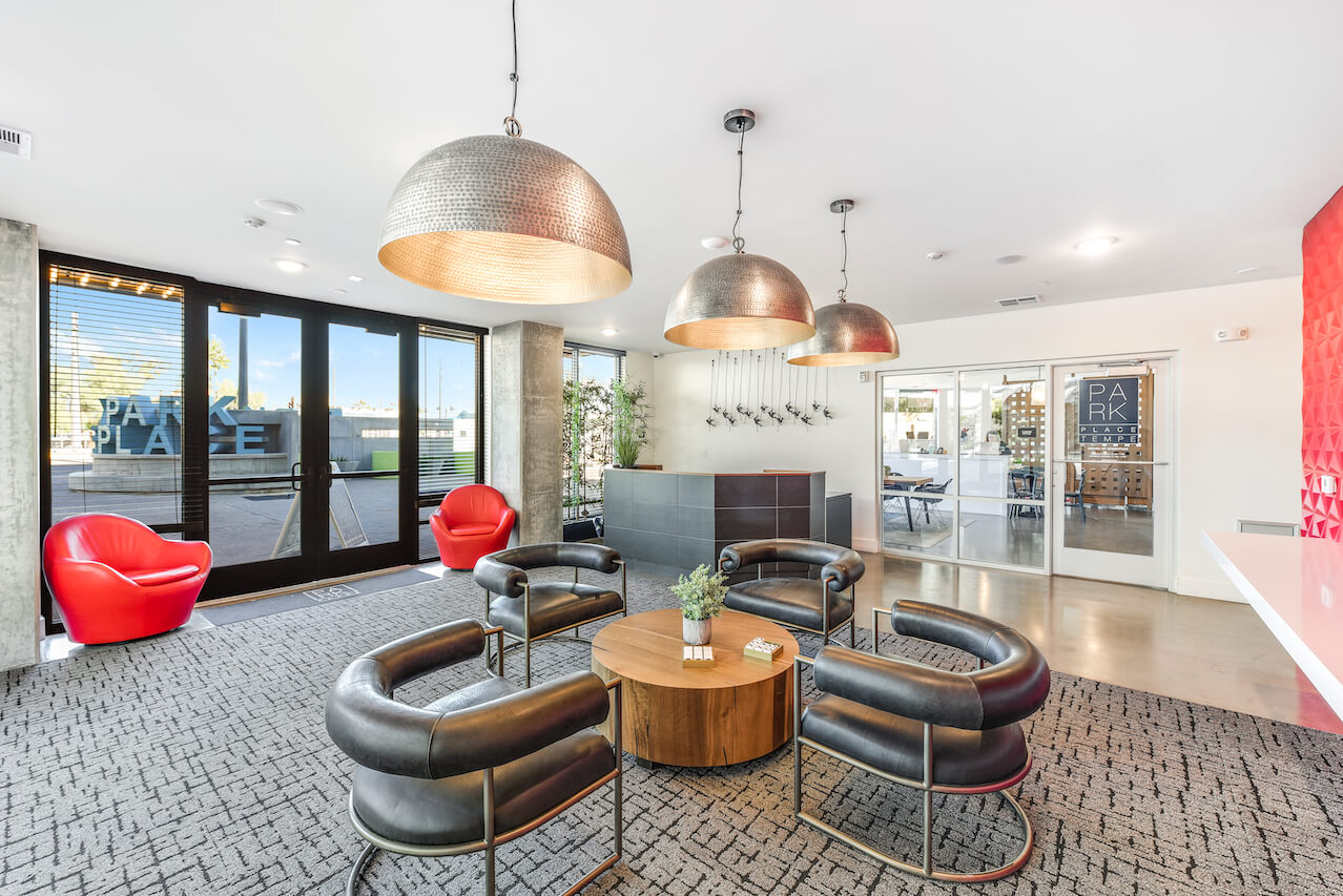 Modern lounge area with hanging lights seating and a reception desk