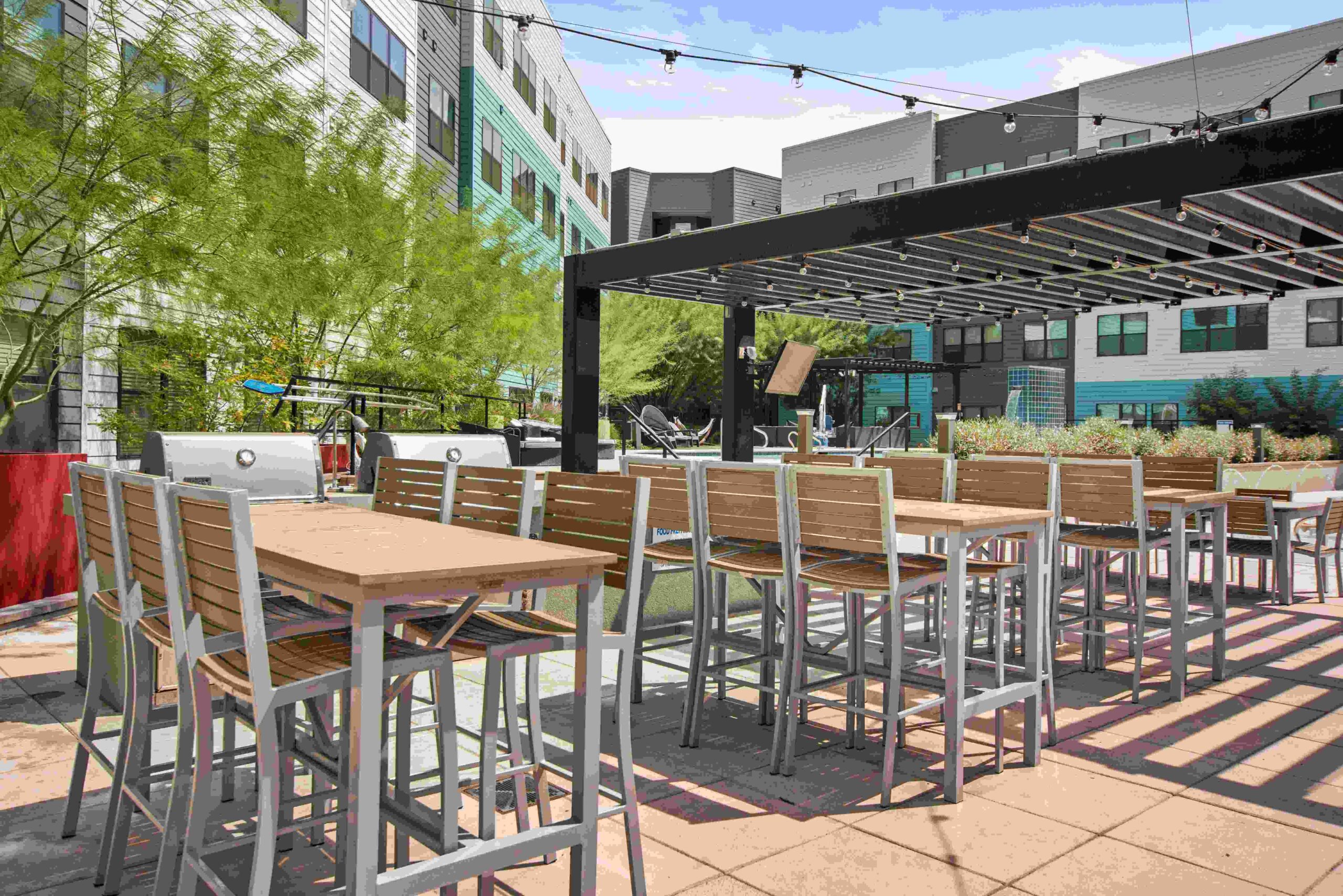 Outdoor dining area with high tables and chairs scaled