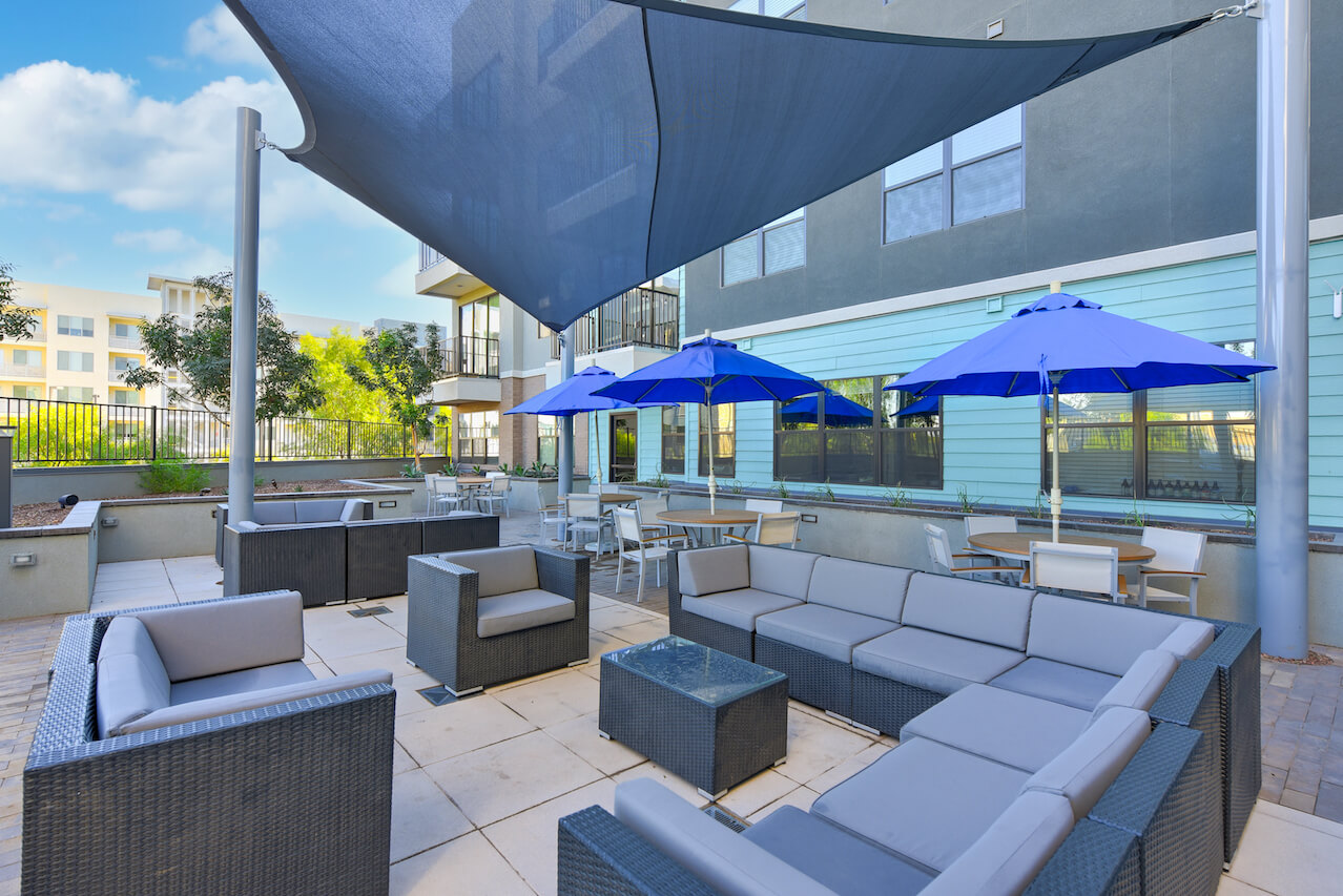Outdoor lounge area with seating and blue umbrellas