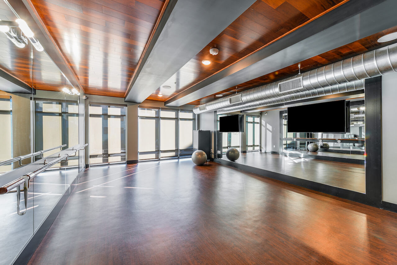 Yoga studio with wooden floors mirrors and large windows